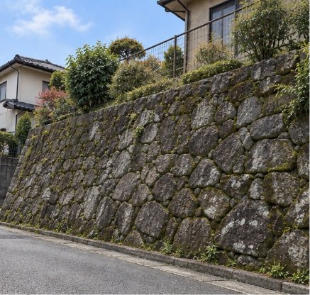 石積み擁壁の例。自然石を積み上げた擁壁の上に住宅が建っている
